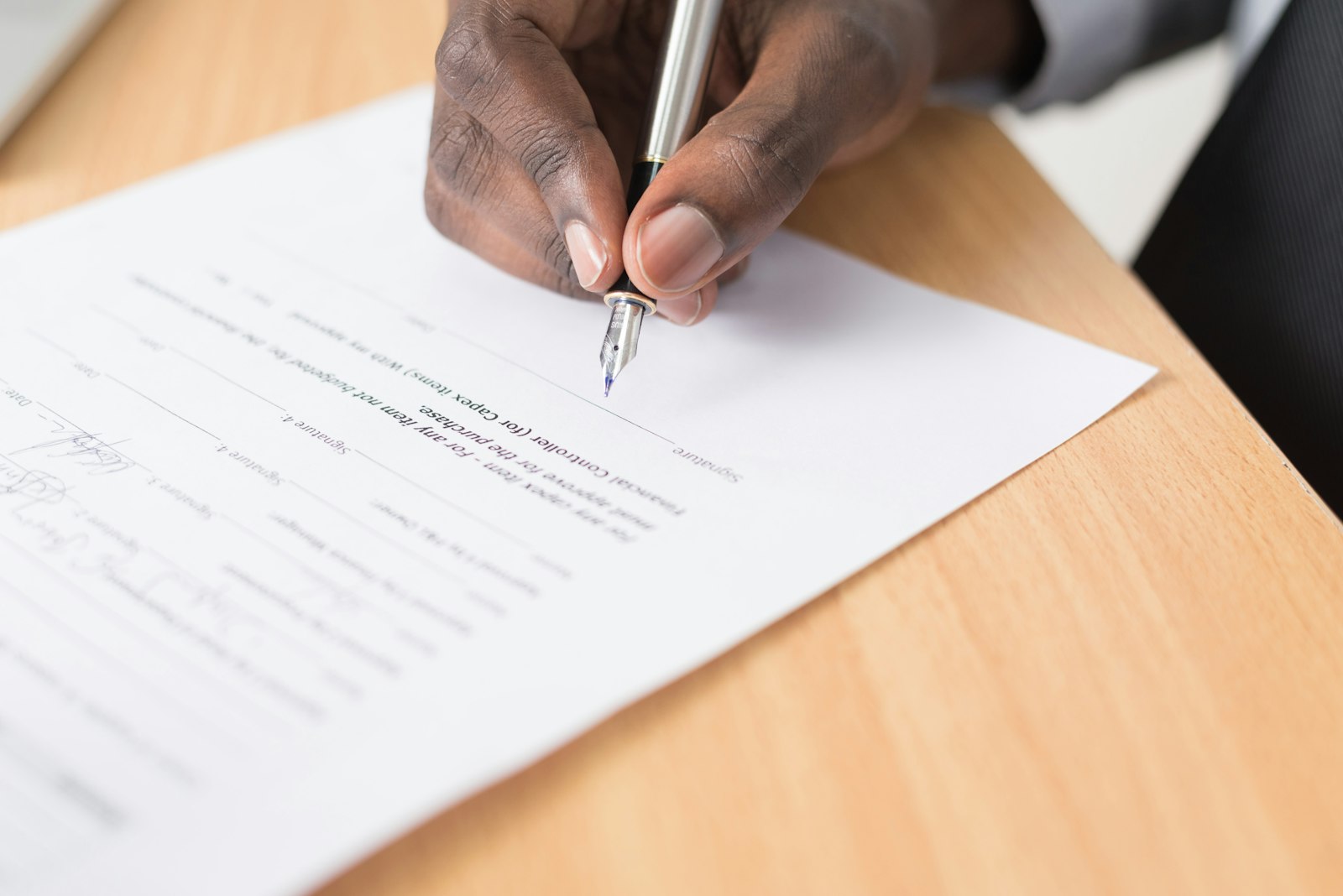 Sample photo of a hand writing on a document, to be replaced